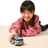 Bluey Muffin vehicle toy shown in use by a child, black and gray car with pink accents rolling forward as the child smiles, illustrating interactive pretend play inspired by the Bluey TV series.