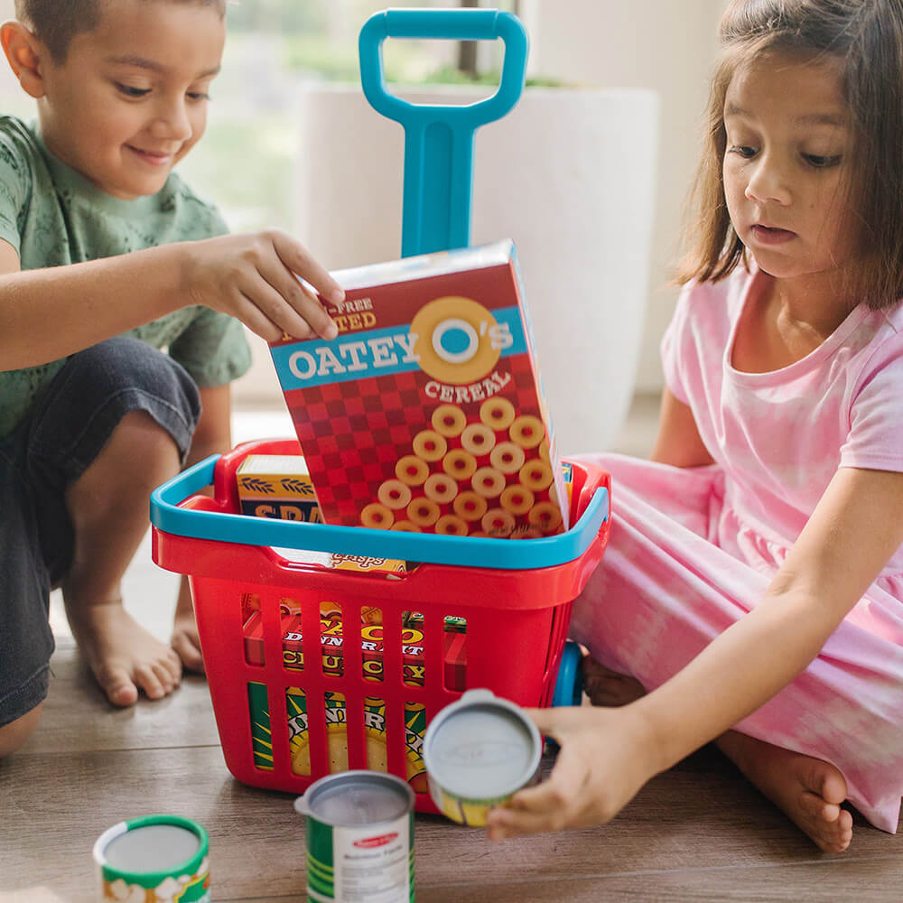 Boy and girl playing with the Melissa and Doug Fill & Roll Grocery Basket Play Set
