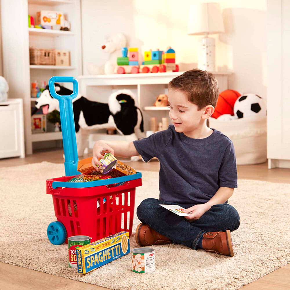 Boy playing with the Melissa and Doug Fill & Roll Grocery Basket Play Set