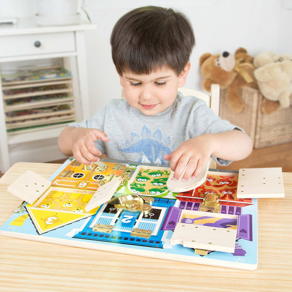 Boy playing with the Melissa and Doug Wooden Latches Board