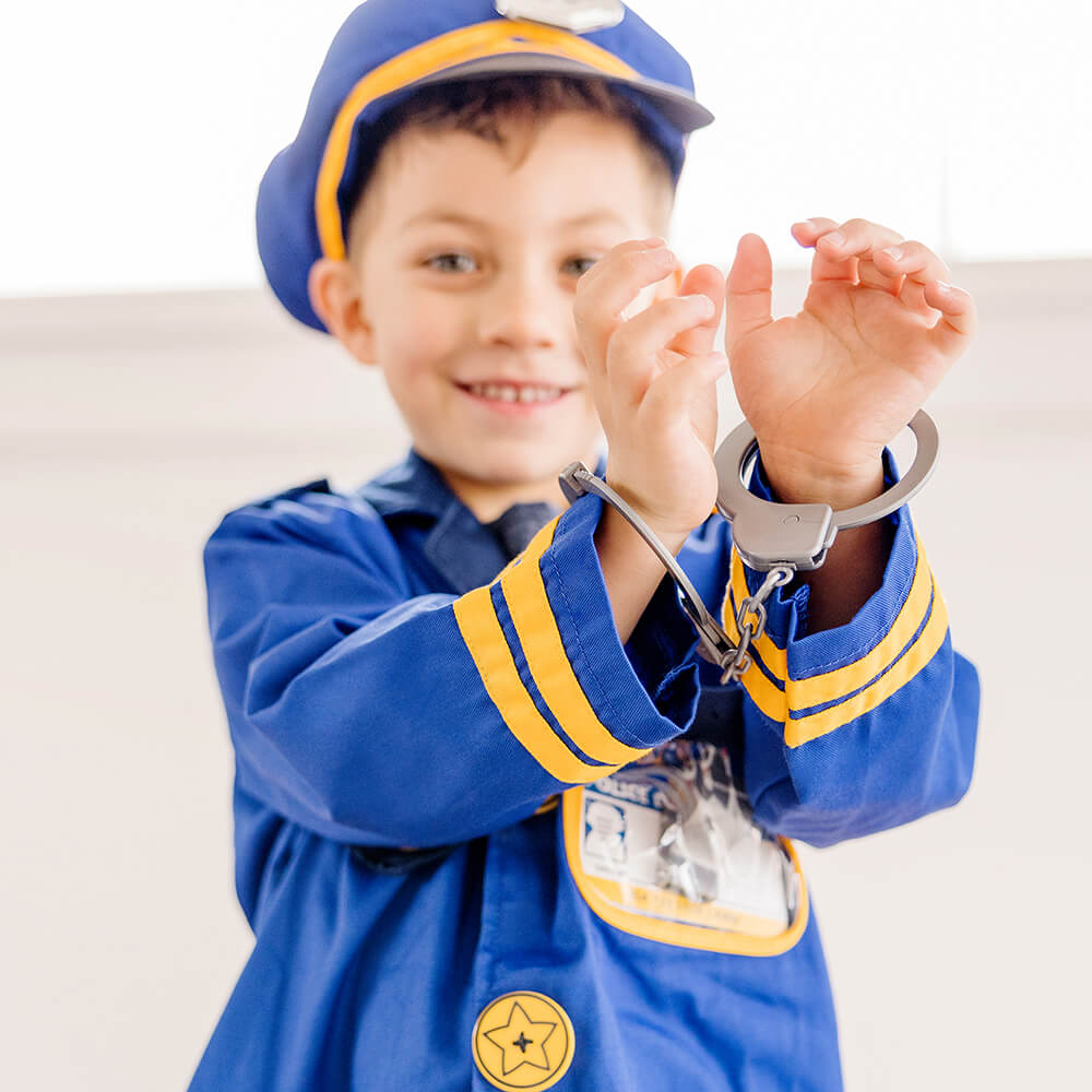 Boy playing wtih toy handcuffs and dressed as a police officer in the Melissa and Doug Police Officer Costume Role Play Set