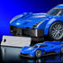 Hot Wheels Cadillac Project GTP Hypercar in blue brick form pairs with a smaller die-cast model and silver display plate, set against a vivid blue studio backdrop.