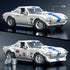 Hot Wheels Corvette Grand Sport brick-built car in white plastic with blue center stripes, alternate wheels installed, classic race livery, and modular parts shown for build and customize play on a dark backdrop.