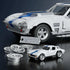Hot Wheels Corvette Grand Sport set featuring white brick-built car with blue stripes, exclusive metal die-cast car, metal signature plate, and extra wheels displayed together on a reflective studio surface.