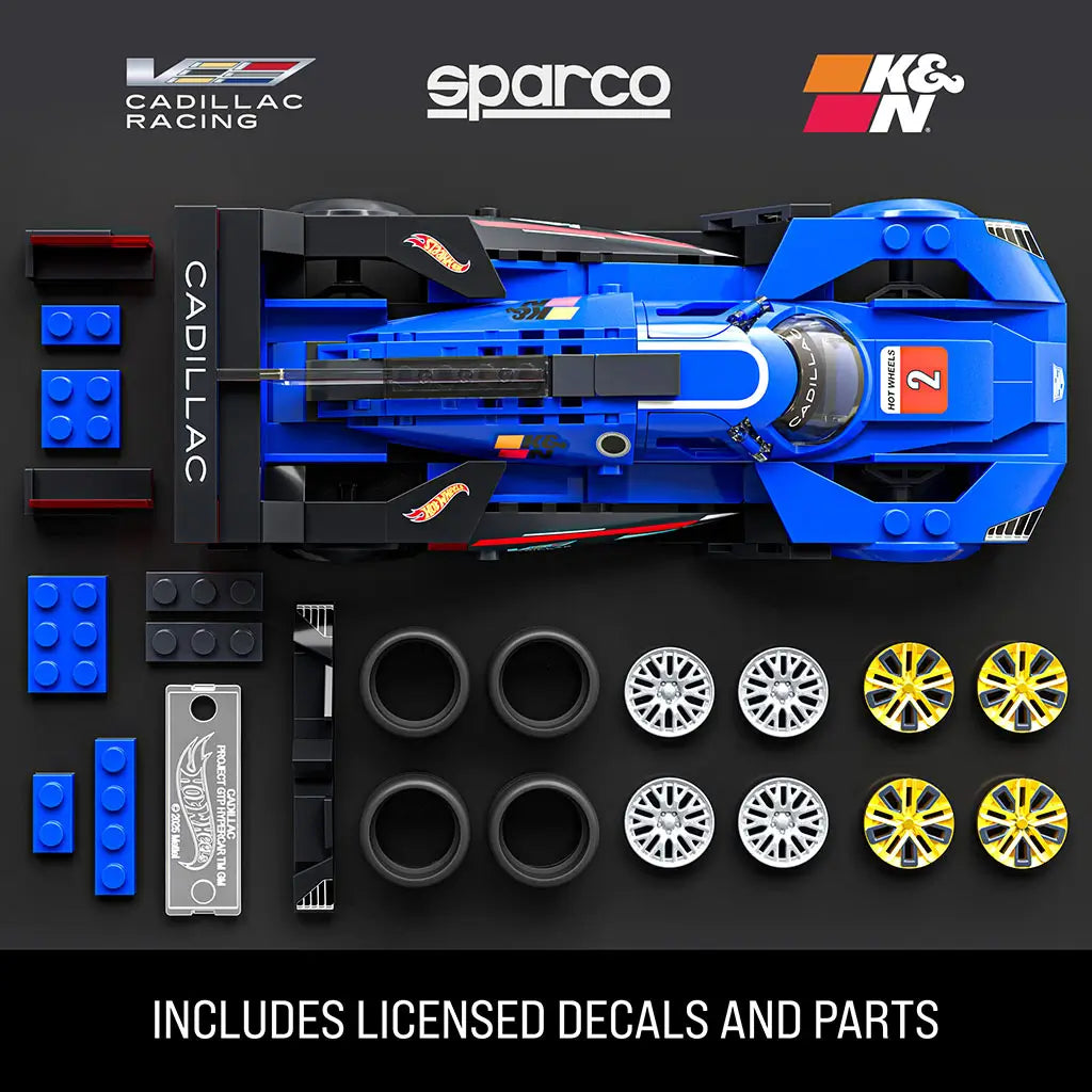 Hot Wheels Cadillac Project GTP hypercar parts layout showing blue plastic body panels, black tires, silver and gold wheels, licensed racing decals, and modular components arranged flat on a dark studio background.