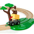 BRIO Safari Railway Set toy shows a brown monkey on a green tree dropping a yellow wooden block onto a black train wagon, set against curved wooden tracks with green base.