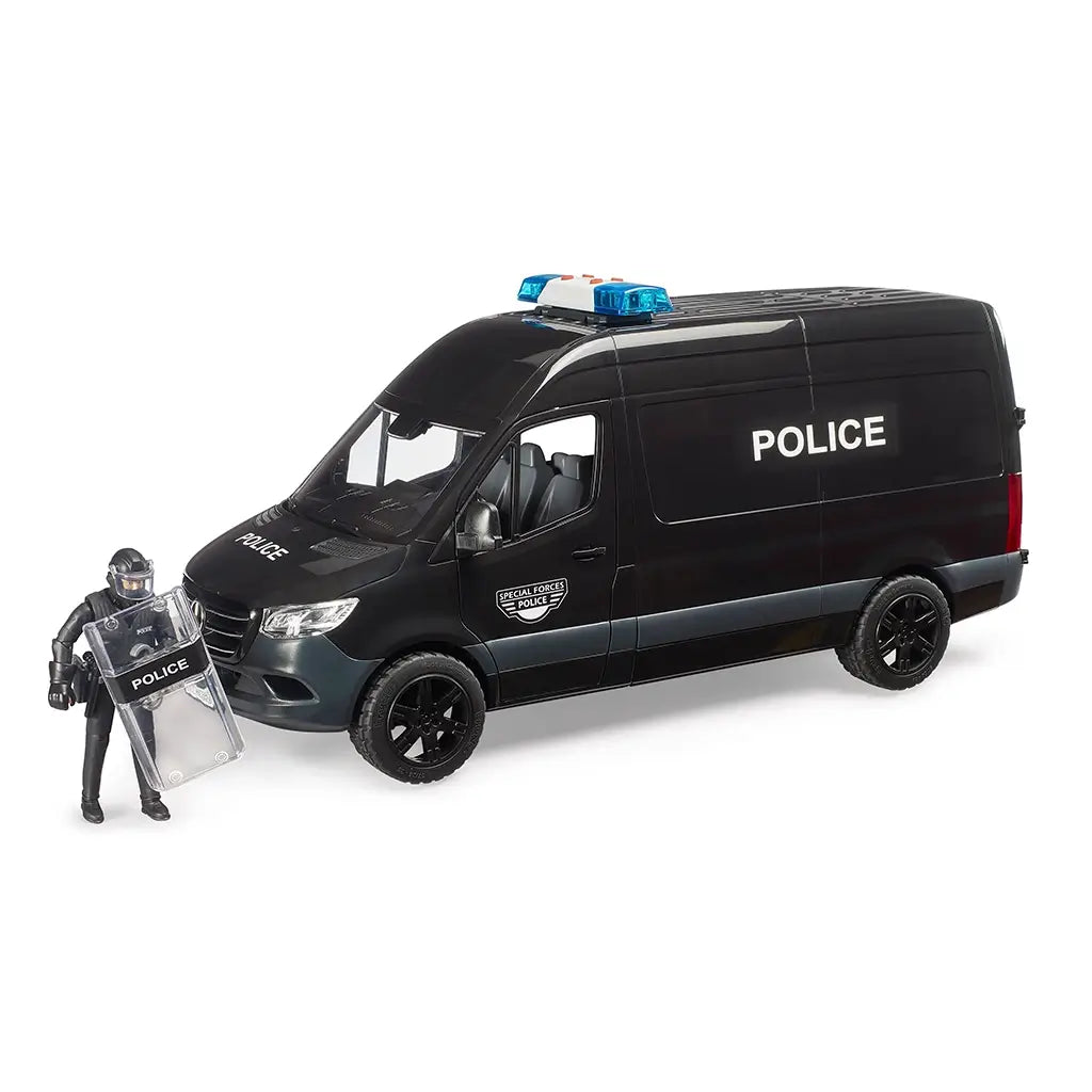 Bruder Mercedes-Benz Sprinter police van toy in black plastic with gray and blue details, shown with a police figure holding a clear riot shield beside the vehicle on white.