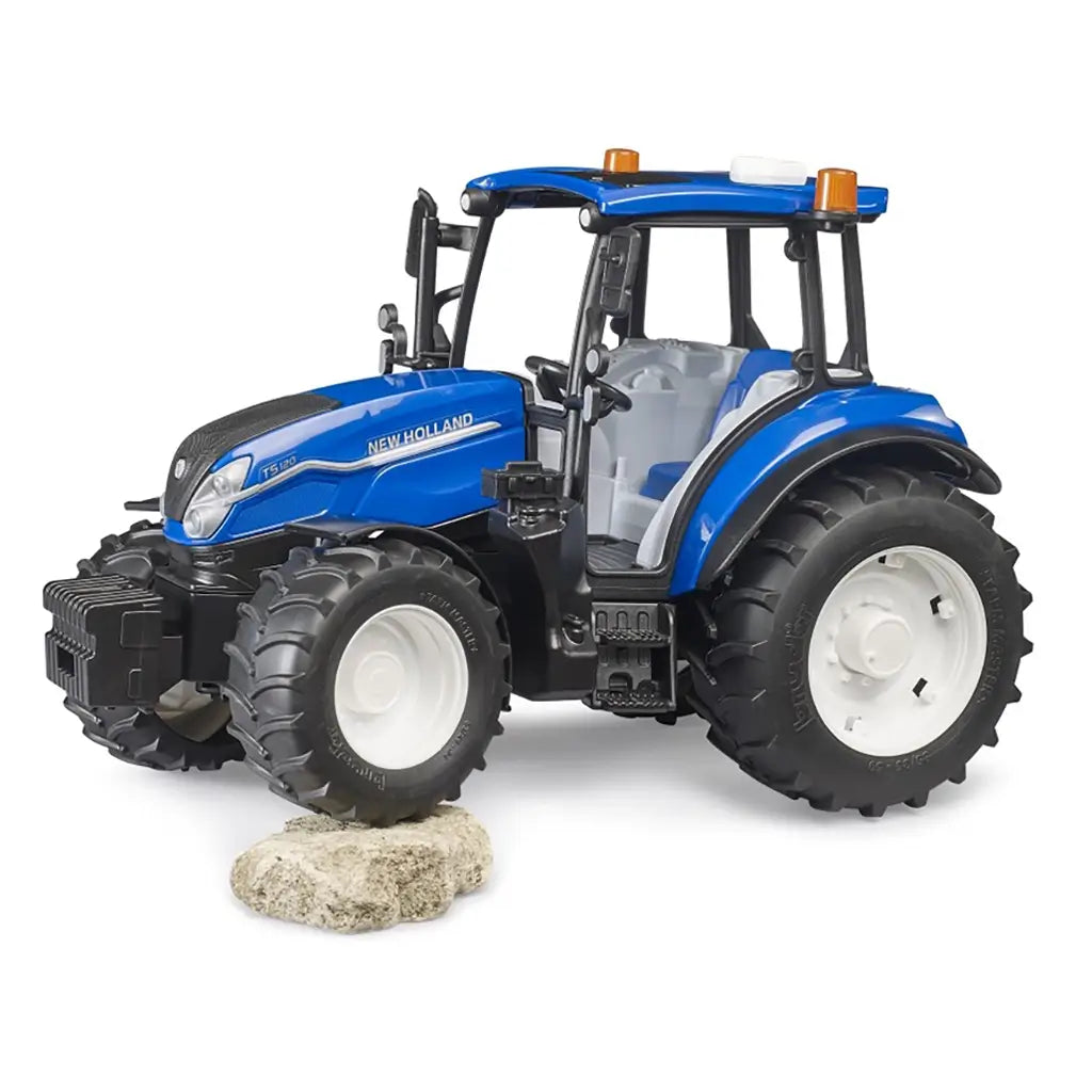 Bruder New Holland T5 120 1:16 toy tractor positioned on rocky terrain, highlighting its realistic suspension, rugged tire grip, and lifelike all-terrain performance for imaginative farm play.