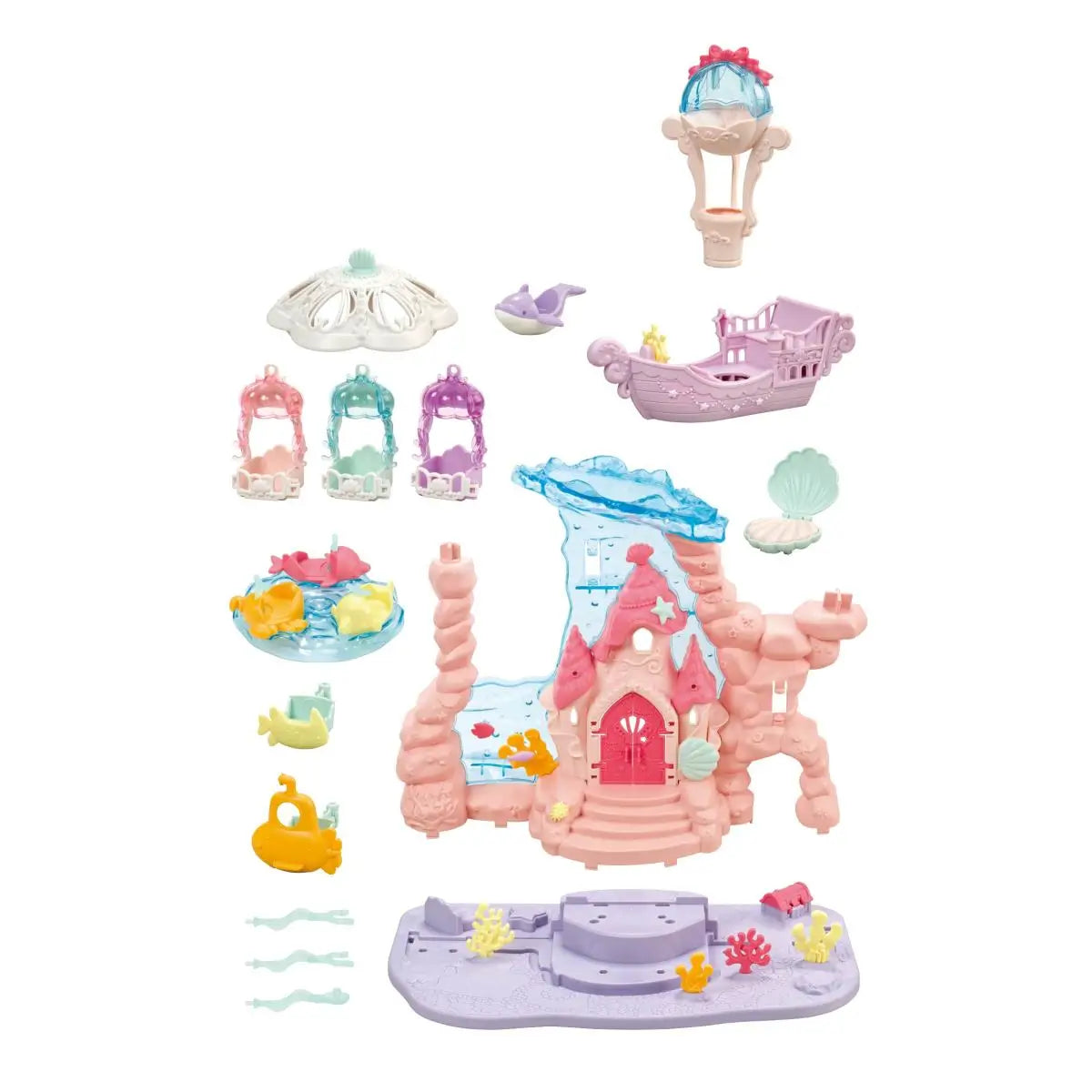 Calico Critters Baby Mermaid Castle accessories display pastel pink castle base, blue wave slide, carousel seats, boat ride, submarine, shell pieces, and coral decorations arranged on white backdrop.