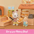 Calico Critters bakery shop playset with cream counters, red brick oven, wooden-style shelves, and rabbit baker holding basket of bread inside cozy dollhouse kitchen scene.