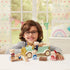 Calico Critters Classic Family Car play scene shows a smiling child with a mint and gold toy car, bear figures, brown suitcase, and accessories in a bright room.