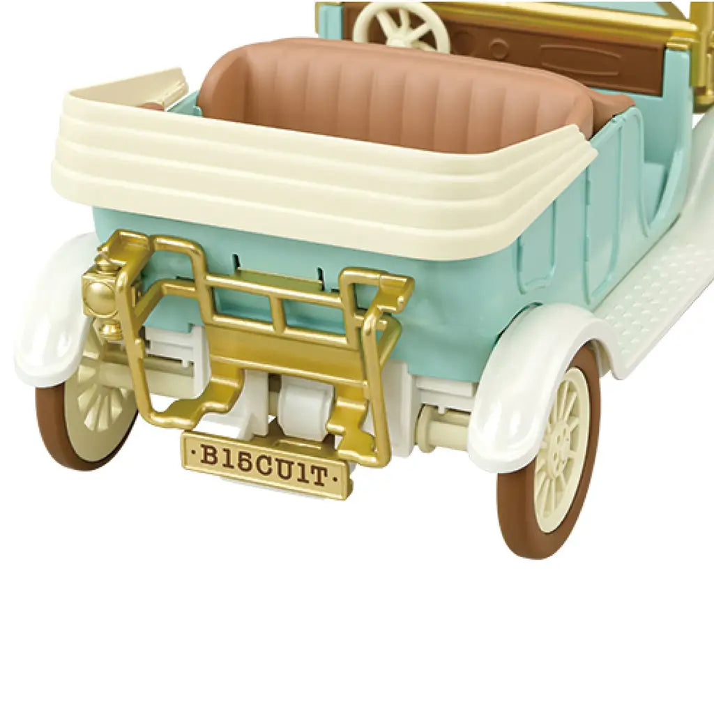 Calico Critters Classic Family Car rear view shows a mint plastic body, cream trim, tan seats, gold luggage rack, white fenders, and brown tires on a white background.