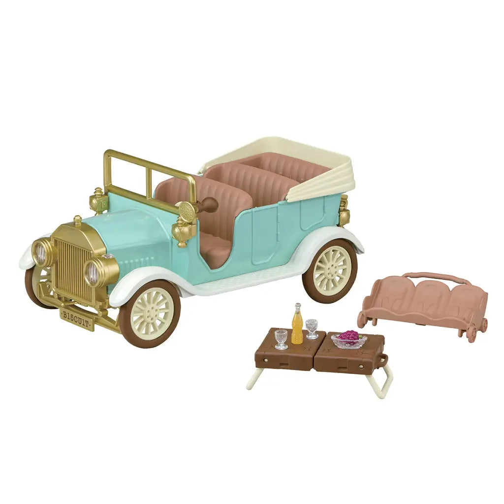 Calico Critters Classic Family Car set features a mint convertible with gold trim, tan seats, brown suitcase picnic table, bench, clear glasses, grapes, and drink.