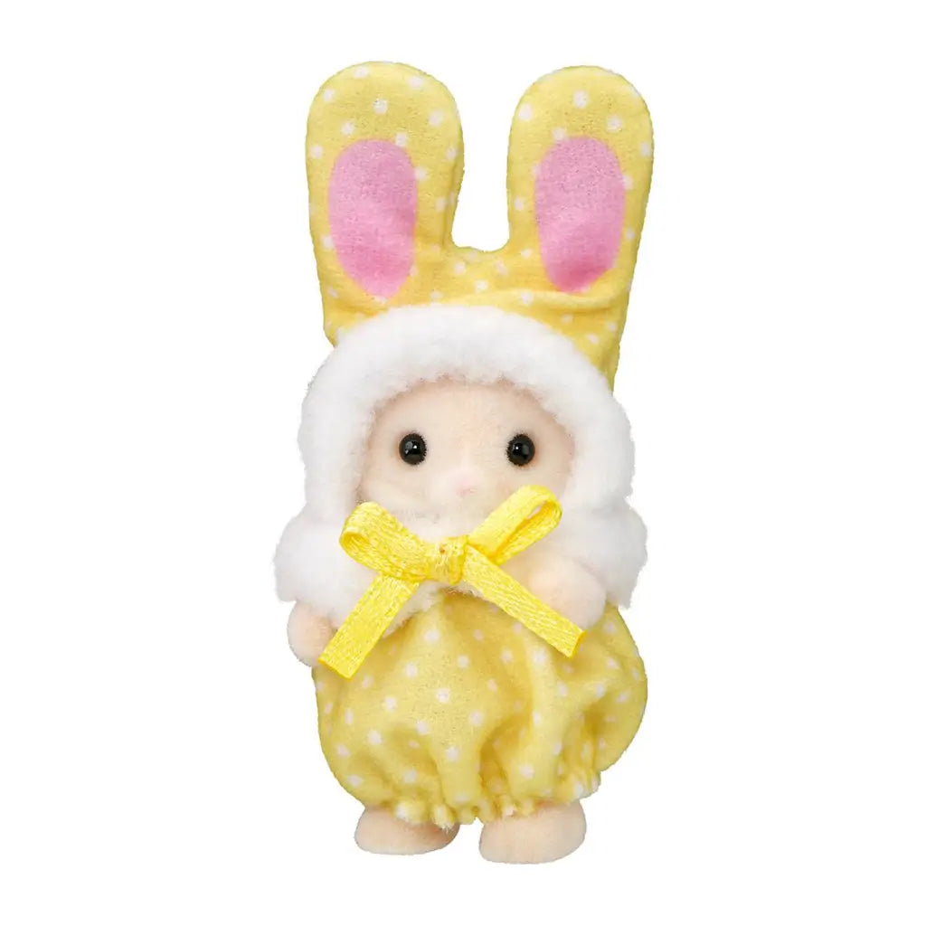 Calico Critters baby figure wears a yellow polka-dot plush bunny costume with tall pink-lined ears, white fuzzy hood trim, and a yellow satin bow on a white background.