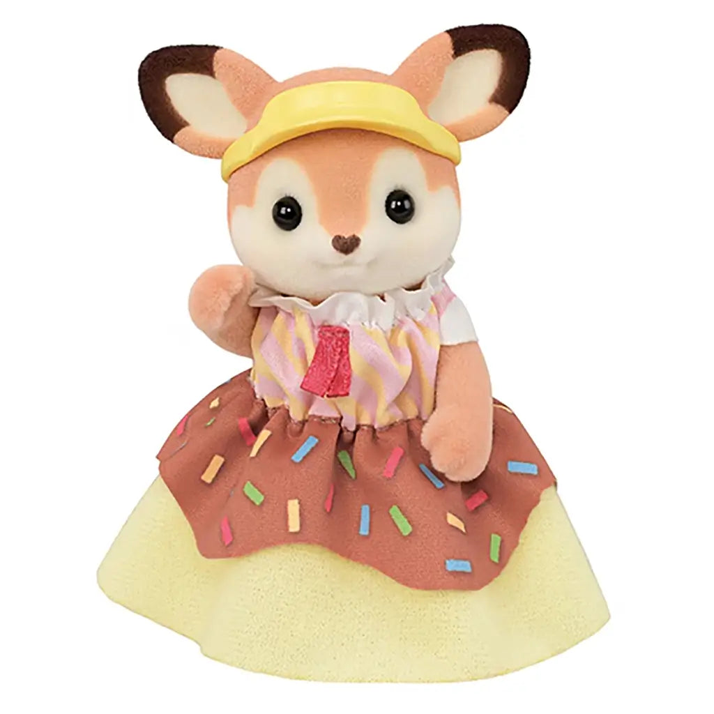Calico Critters fox figure in sprinkle-pattern skirt and yellow visor waves with a friendly smile, dressed to match the donut-themed Dip Dip Donuts wagon toy set.