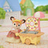 Calico Critters fox figurine dressed in sprinkle-patterned skirt and yellow visor stands beside a toy donut fryer cart with yellow base, pink umbrella, and illustrated donut menu wheel.
