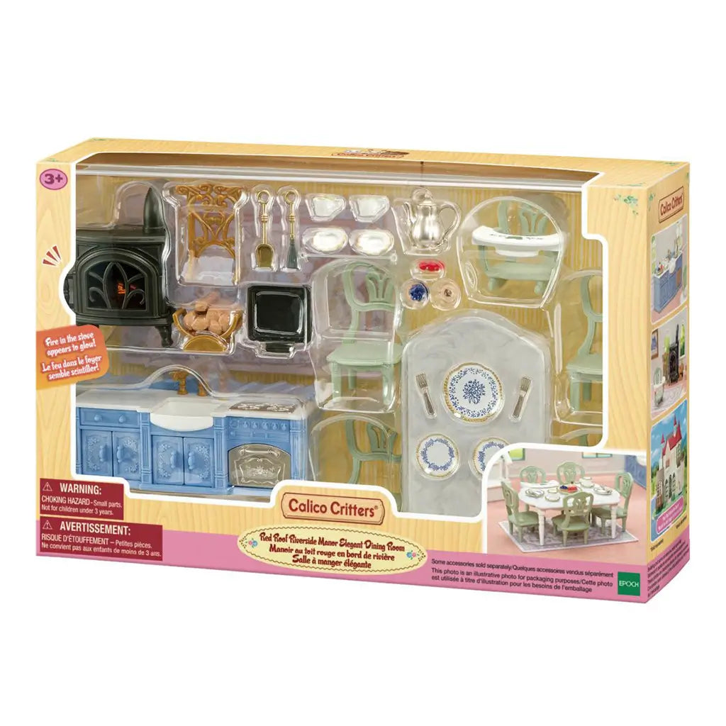 Calico Critters Elegant Dining Room boxed playset displays blue kitchen cabinets, black stove, pale green chairs, white tableware, tea set, desserts, and dining table.