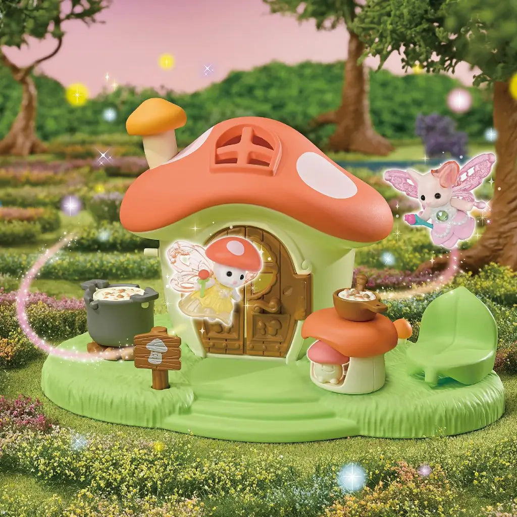 Calico Critters Fairy Mushroom House playset features a green base and orange mushroom roof with fairy figures, cooking accessories and chair in a sparkling garden scene.
