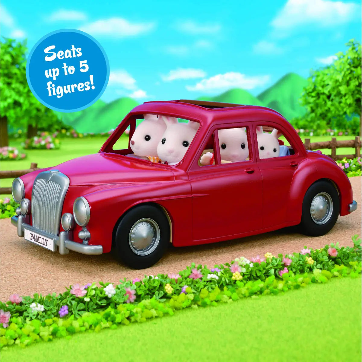 Calico Critters Family Cruising Car toy in bright red with rabbit family figures seated inside, driving on a scenic path surrounded by flowers and greenery, labeled “Seats up to 5 figures!”