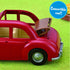 Calico Critters Family Cruising Car close-up showing shiny red toy car with tan convertible roof partially open, displayed on green grass with a label reading “Convertible roof!”