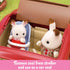 Calico Critters red car interior showing rabbit figures seated, one in a blue baby car seat converted from a stroller attachment, demonstrating removable seat use feature.