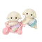 Calico Critters Flora Rabbit Twins set features two cream flocked baby rabbits in pink and aqua outfits, posed with a pastel pink tricycle against a white background.