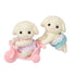 Calico Critters Flora Rabbit Twins set features two cream flocked baby rabbits in pink and aqua outfits, posed with a pastel pink tricycle against a white background.