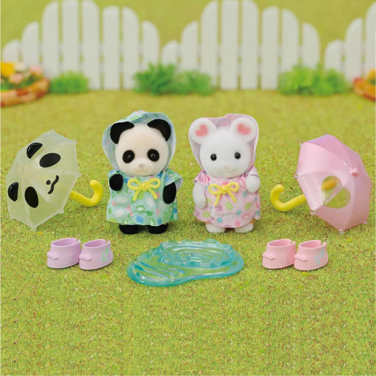 Calico Critters Nursery Friends Rainy Day Duo with raincoats and umbrellas on a grassy background.