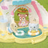 Calico Critters baby animal figures playing in shallow pool area with two floating swim rings beneath pastel castle arch with rainbow and music note decorations.