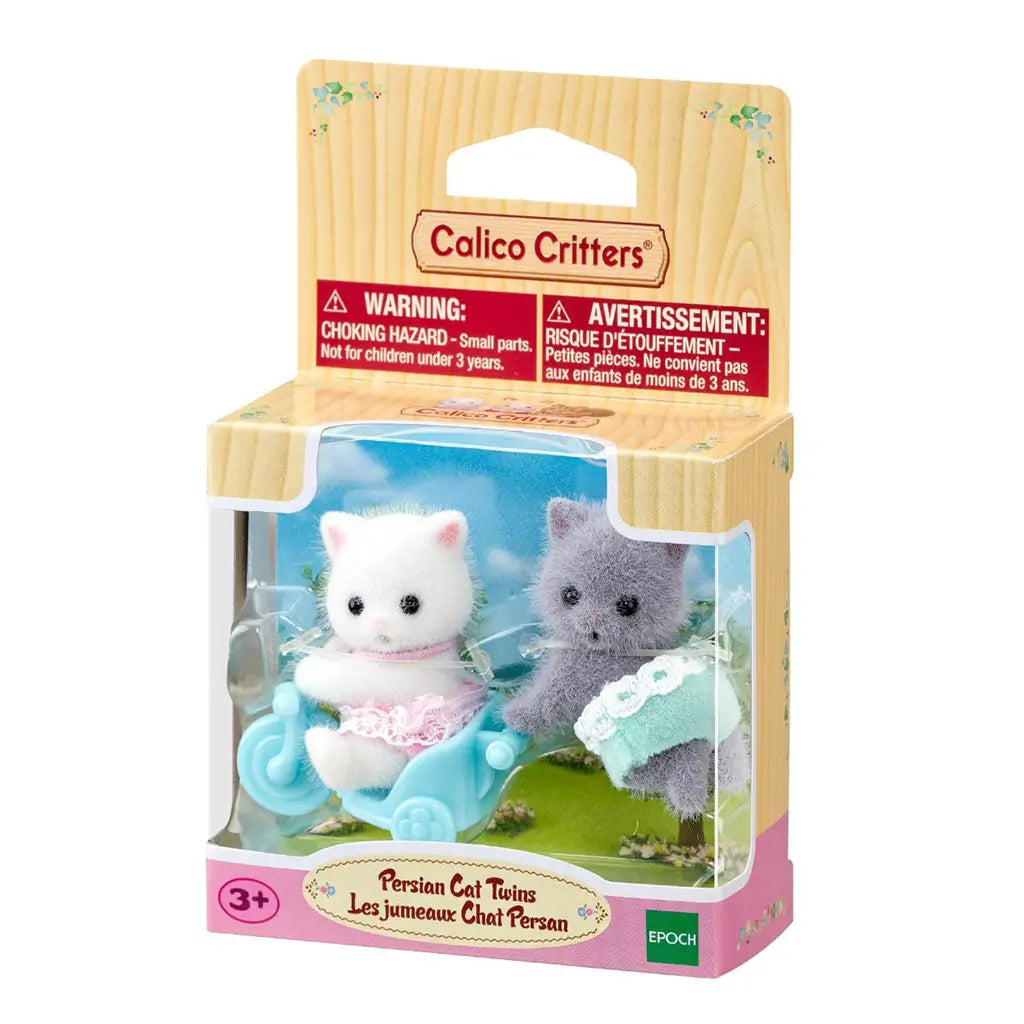 Calico Critters Persian Cat Twins package displays white and gray flocked kittens in pink and aqua outfits with a light blue tricycle inside a windowed retail box.