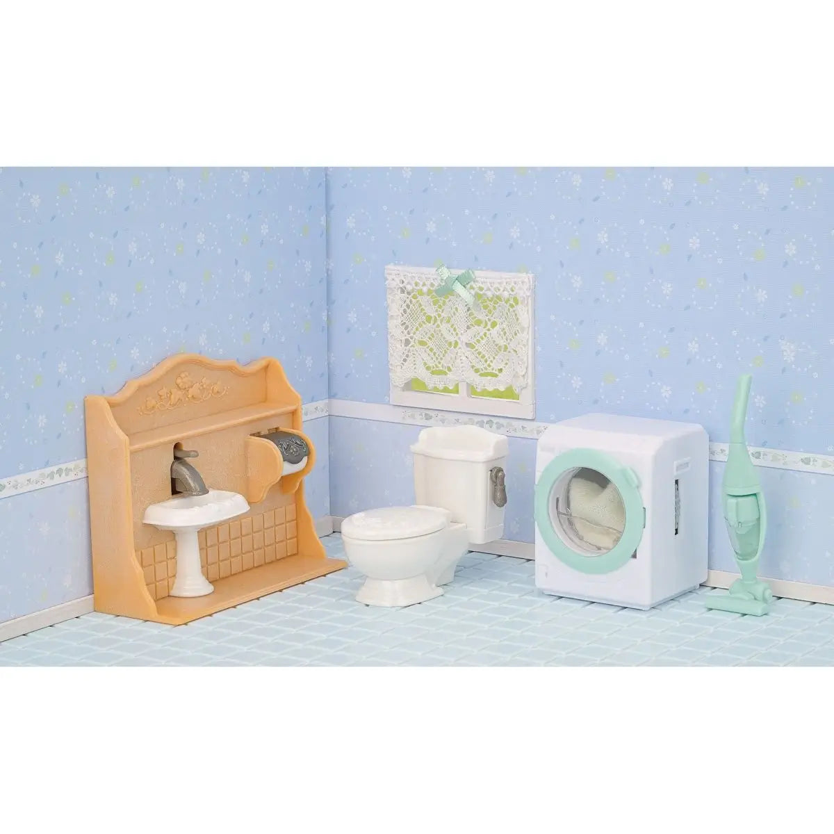 Calico Critters bathroom and laundry display shows peach sink vanity, white toilet, mint washing machine, and upright vacuum arranged in blue wallpapered dollhouse room.
