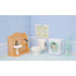 Calico Critters bathroom and laundry display shows peach sink vanity, white toilet, mint washing machine, and upright vacuum arranged in blue wallpapered dollhouse room.