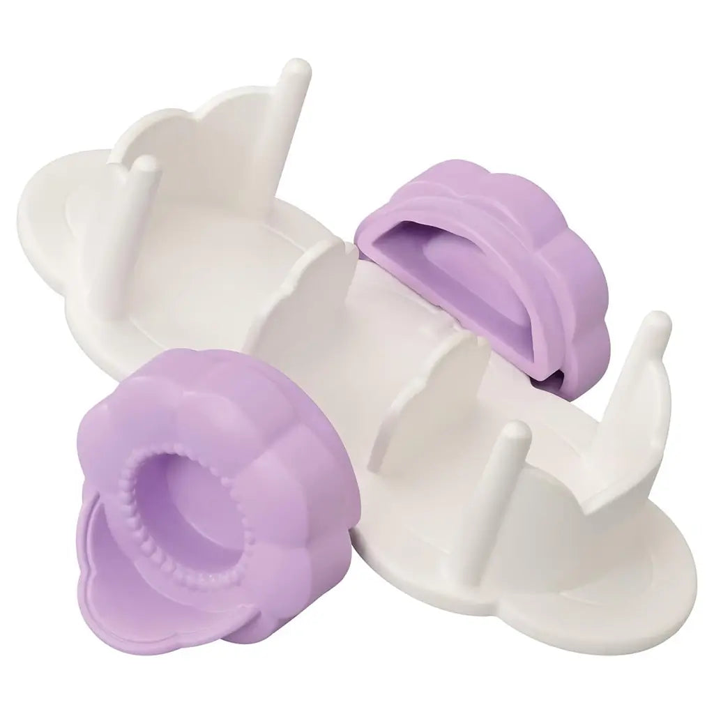 White and lavender Calico Critters see-saw toy shaped like clouds and flowers, made of smooth plastic with curved ends, designed as an accessory piece for the Playtime Castle Nursery set.