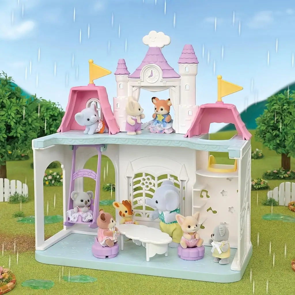 Calico Critters Playtime Castle Nursery featuring pastel castle structure, musical motifs, and animal figurines, with changeable weather effect showing raindrops in a lush green outdoor setting.