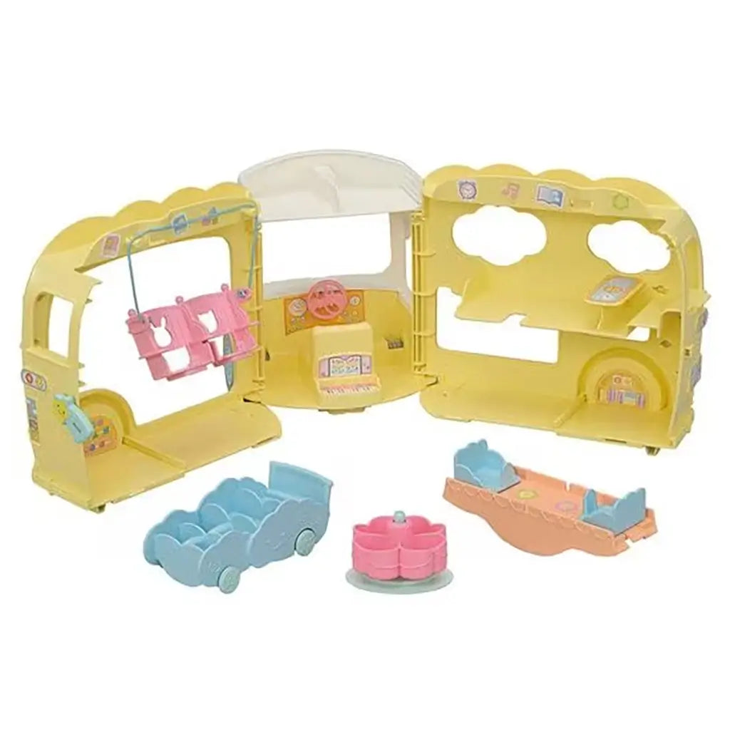 Calico Critters Rainbow Fun Nursery Bus opened to reveal interior play areas with pink swing, piano keyboard detail, pastel seating, merry-go-round, and seesaw.