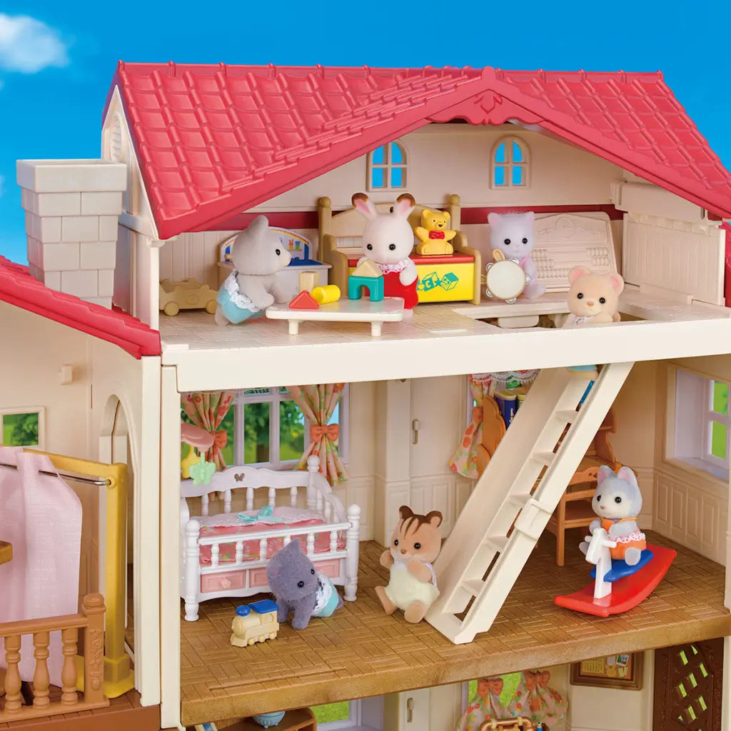 Calico Critters Red Roof Country Home interior close-up showing multiple rooms with wooden floors, toy furniture, baby crib, ladder, and animal figures playing together.