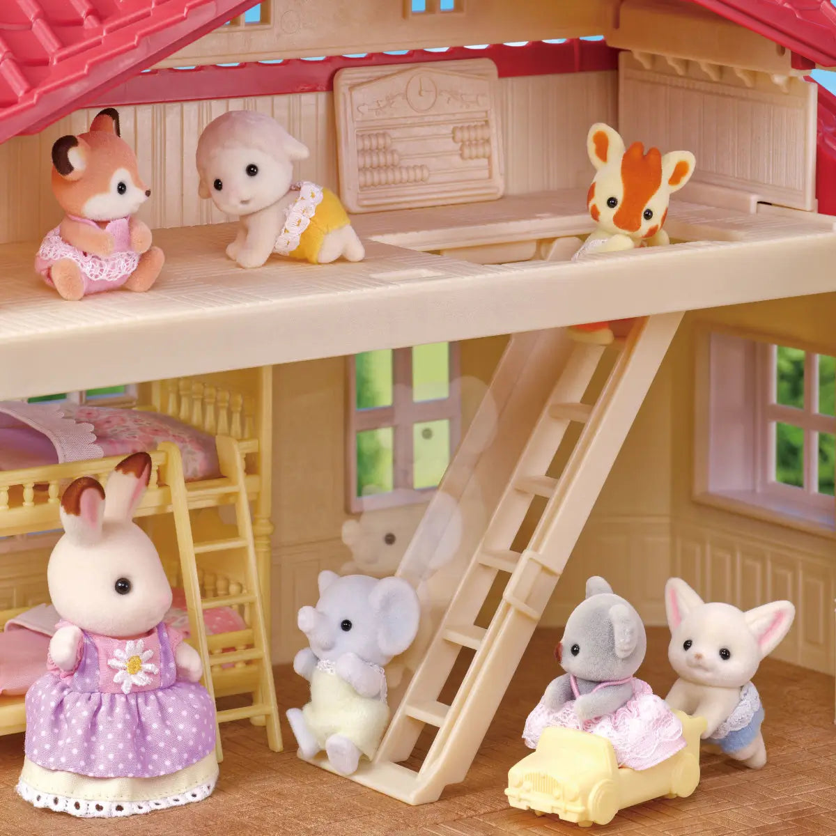 Calico Critters Red Roof Country Home closeup shows beige plastic interior with bunk beds, staircase ladder, arched windows, and animal figures arranged inside detailed dollhouse rooms.