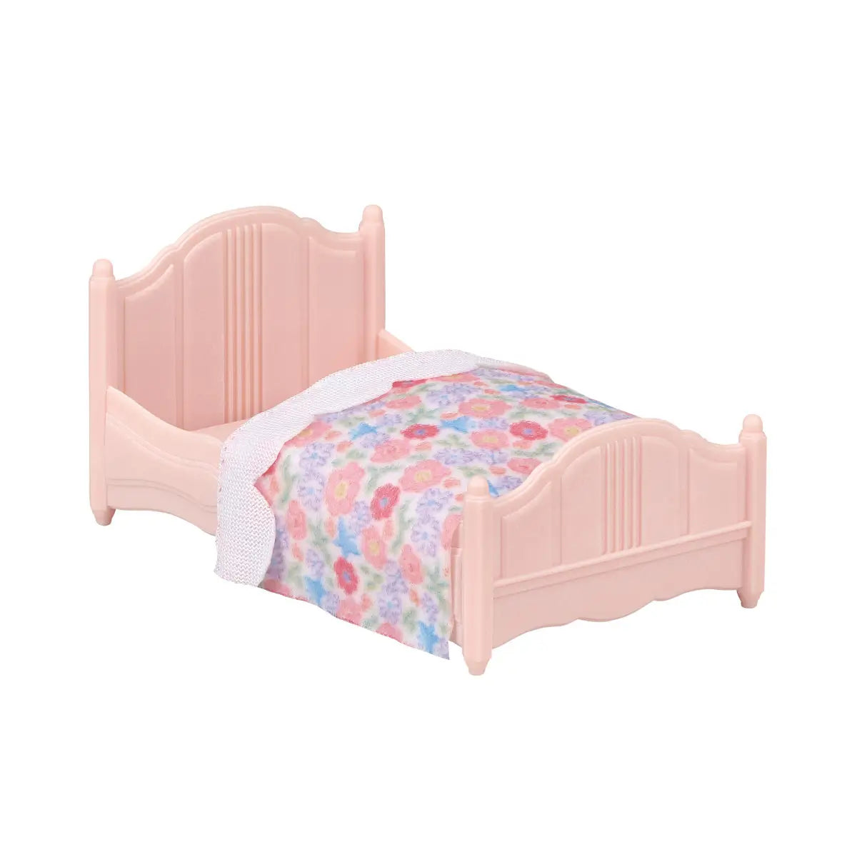 Light pink plastic miniature bed with curved headboard and footboard, featuring a colorful floral-print blanket and white lace trim, part of the Calico Critters cozy cottage furniture collection.