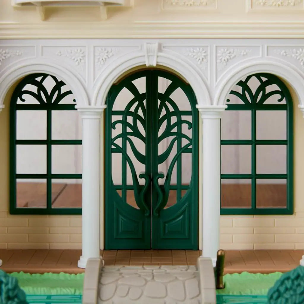 Calico Critters Red Roof Riverside Manor entrance has dark green arched double doors and windows, white molded columns, floral trim, stone path, and green lawn.