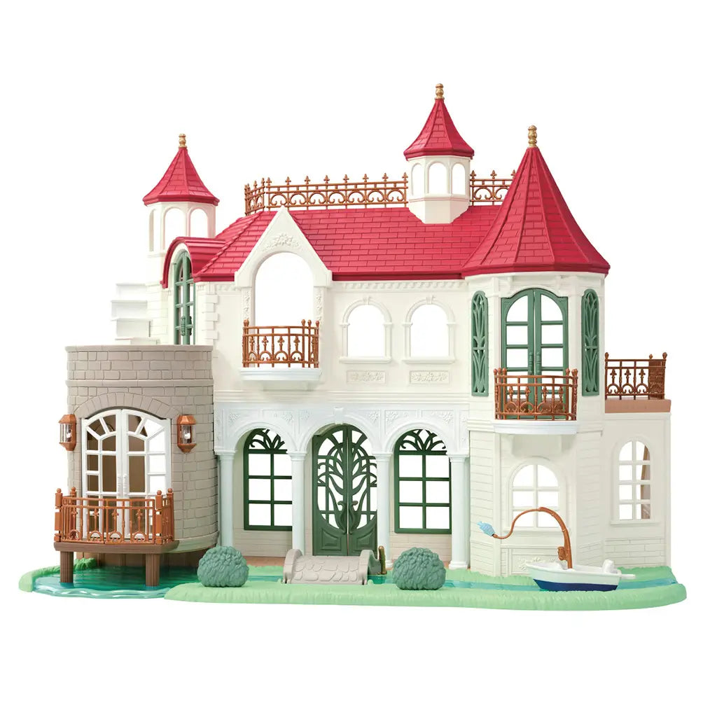 Calico Critters Red Roof Riverside Manor playset has white textured walls, red turret roofs, green arched doors, bronze balconies, river base, shrubs, and fishing boat.