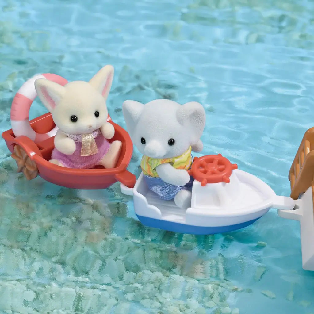 Calico Critters Seal Sailor's Leisure Boat scene shows a white and blue small boat linked to a red dinghy, carrying elephant and rabbit figures across turquoise water.