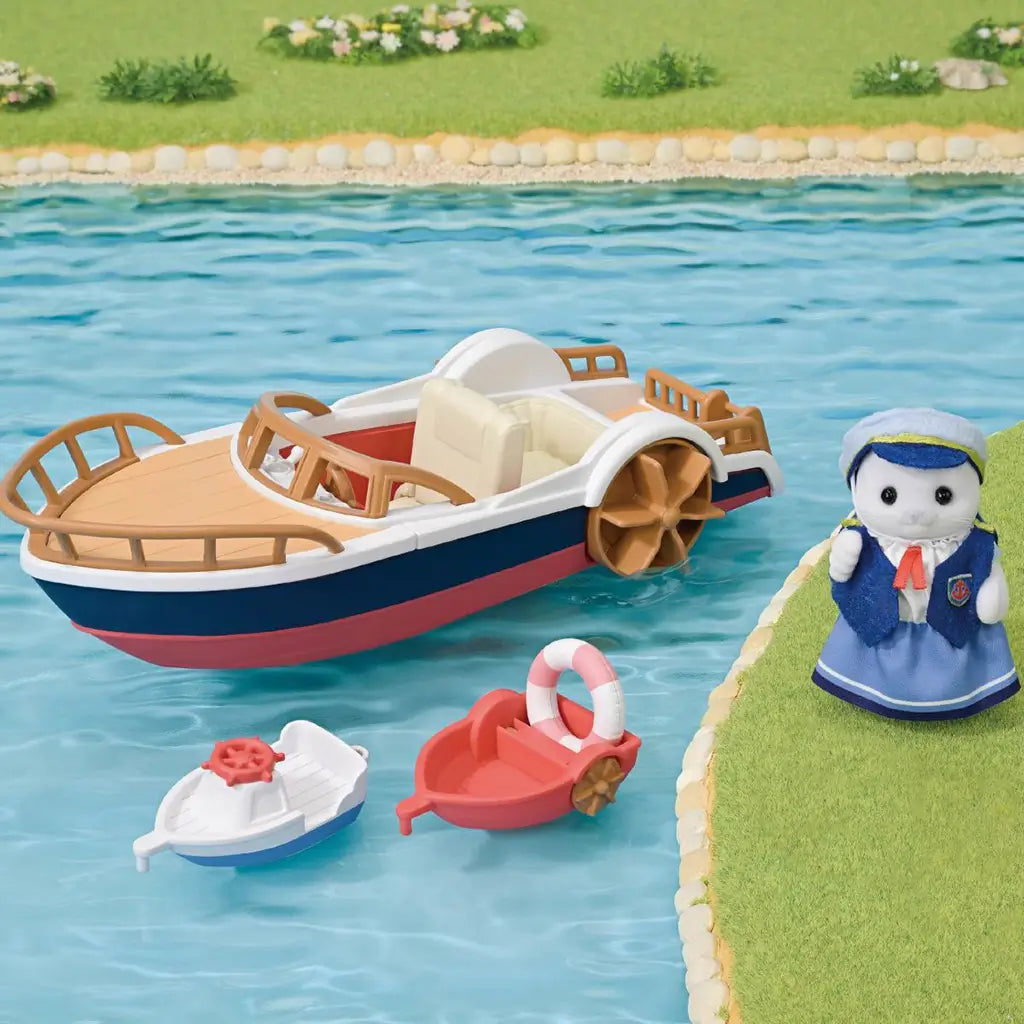 Calico Critters Seal Sailor's Leisure Boat set shows a navy, white, and red paddle boat with two small boats and a sailor figure beside a grassy turquoise waterway.