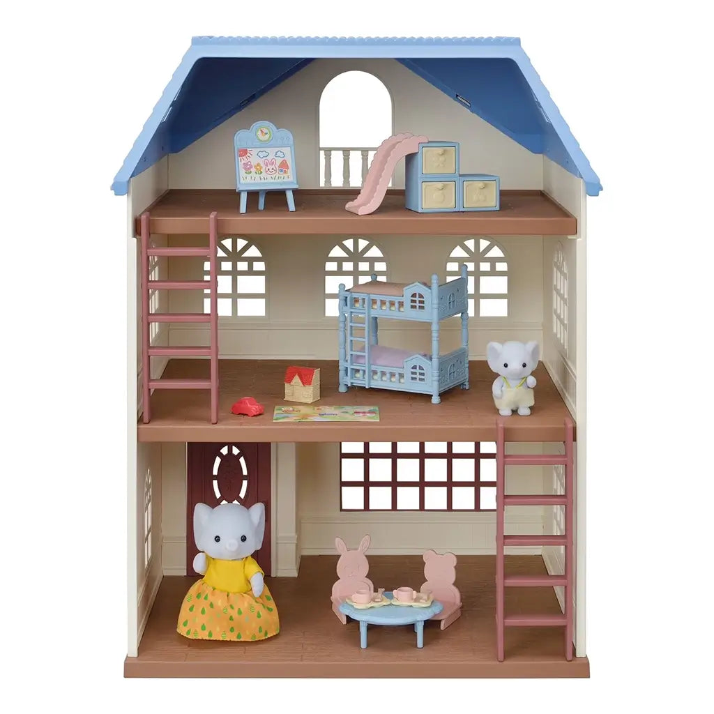 Calico Critters Sky Blue Terrace dollhouse front view reveals three floors with arched windows, wooden ladders, blue bunk bed, play slide, table, and two critter figures inside.