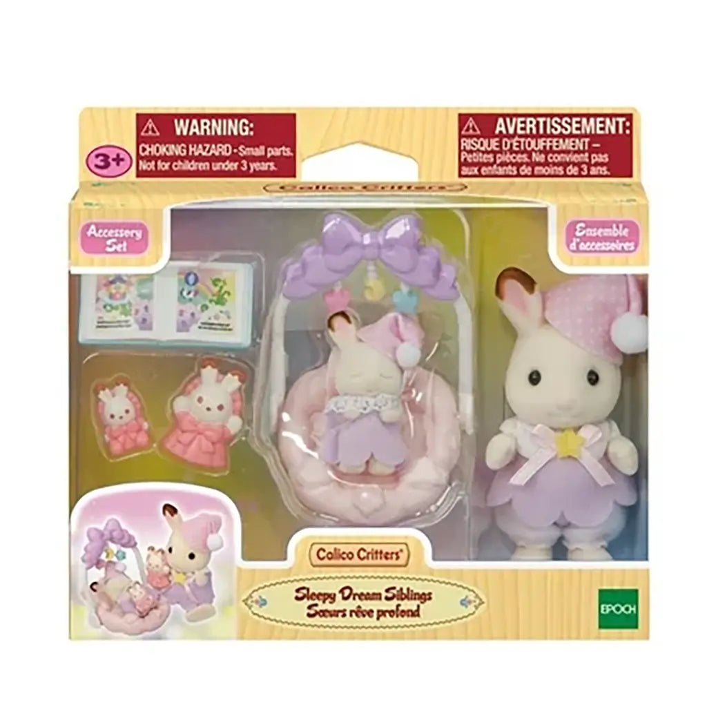 Front packaging of Calico Critters Sleepy Dream Siblings playset, showing accessories including cradle, plush bunnies, storybook, and dolls inside a clear display box.