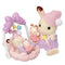Calico Critters Sleepy Dream Siblings set featuring a cream bunny in purple pajamas with a pink nightcap, holding toys beside a baby bunny resting in a pastel pink cradle swing.