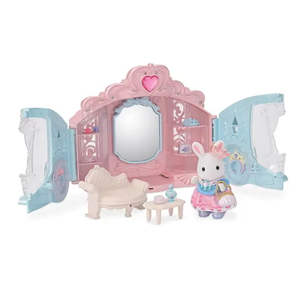 Calico Critters Style & Sparkle Dressing Room toy playset opened to reveal pink and blue carriage with mirror, sofa, table, accessories, and rabbit doll in dress holding handbag.