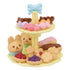 Tiered cake stand from Calico Critters Sweets Party Set holding toy cupcakes shaped like rabbits and bears, tarts, cookies, eclairs, and candy with pastel details.
