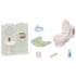 Calico Critters Toilet Set contents including miniature white toilet, sink, floral rug, child seat, brush, cleaner bottle, and toilet paper holder with gold cover.