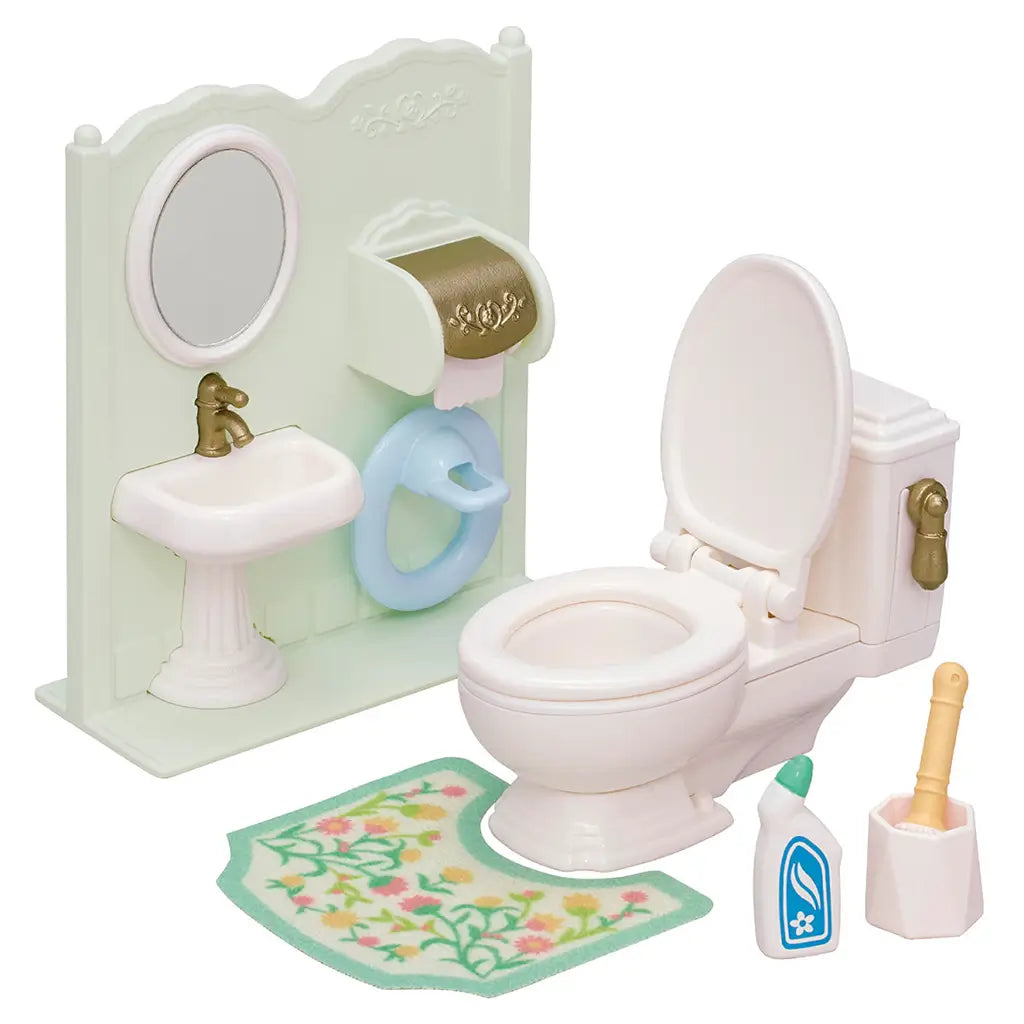 Calico Critters Toilet Set with miniature white toilet, sink with mirror, gold faucet, floral rug, child seat, toilet paper holder, brush, and cleaner bottle.