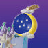 Calico Critters fairy castle moon has a deep blue starry disk framed by a yellow crescent, pearly clouds, and a gold shooting star above a white castle on purple.